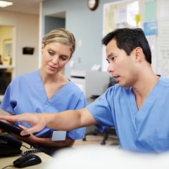 male-and-female-nurse-working-at-nurses-station-picture-id465354635 (1)-min